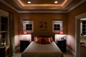 bedroom with recessed lights in the ceiling and two bedside tables with lamps