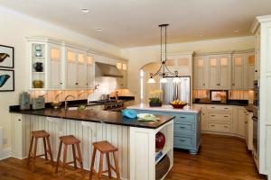 view of kitchen with two large countertops, one with a dining bar, and a kitchen island, backlit cabinets