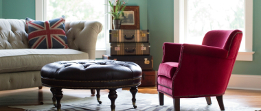 red armchair, leather footrest, and beige couch in living room