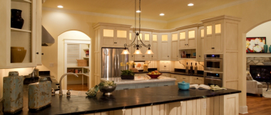 ktichen with two sets of counters, stainless steel appliances, kitchen island and dining bar, and backlit cabinets