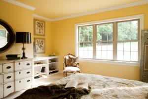 master bedroom with yellow walls and white trim