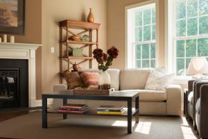 living room with fireplace, shelves, couch, two armchairs, and coffee table