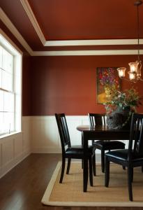 dining room with red walls molding on ceiling and trim