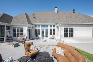house with large outdoor patio including fire pit and hot tub