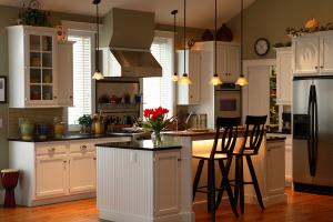 kitchen with white cabinets, black countertops, kitchen island with dining bar and stainless steel appliances