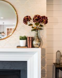 vase of flowers on fireplace mantel with wallpaper accent