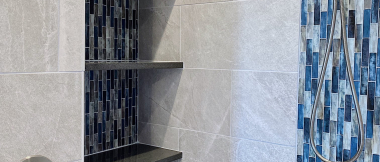 glass tile waterfalls in walk-in shower with built-in shelves