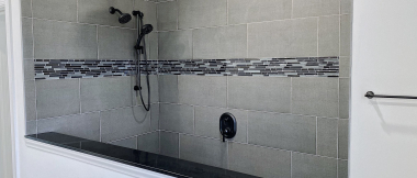 open shower with dual showerheads and tile accent