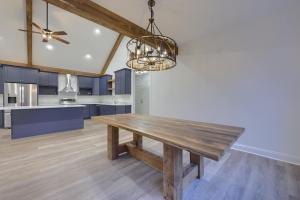 wood table and unique lighting fixture in dining area next to kitchen