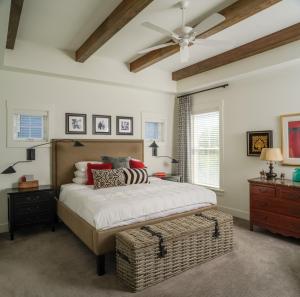 bedroom with exposed beams and storage ottoman