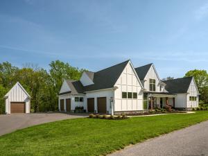 modern farmhouse custom home with 4-bay attached garage and detached garage