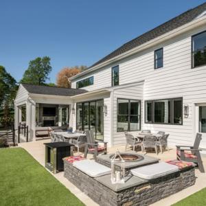 outdoor patio featuring a fire pit and multiple seating areas on a modern farmhouse custom home