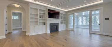 fireplace with large tv above it and built-in shelves and cabinets